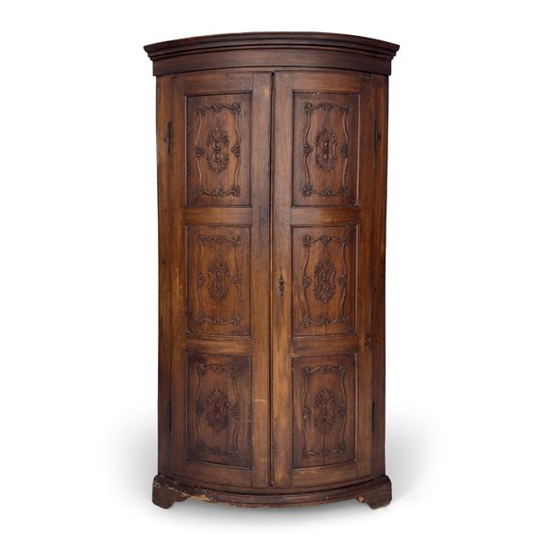 Antica angoliera di noce a due ante bombate e intagliate