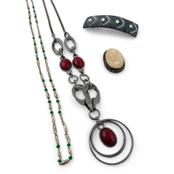 Due collane, un fermacapelli e un pendente di diversa forma e materiale