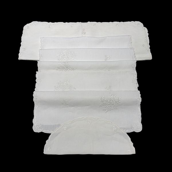 Tovaglia in lino bianco arricchita da ricami con mazzi di roselline