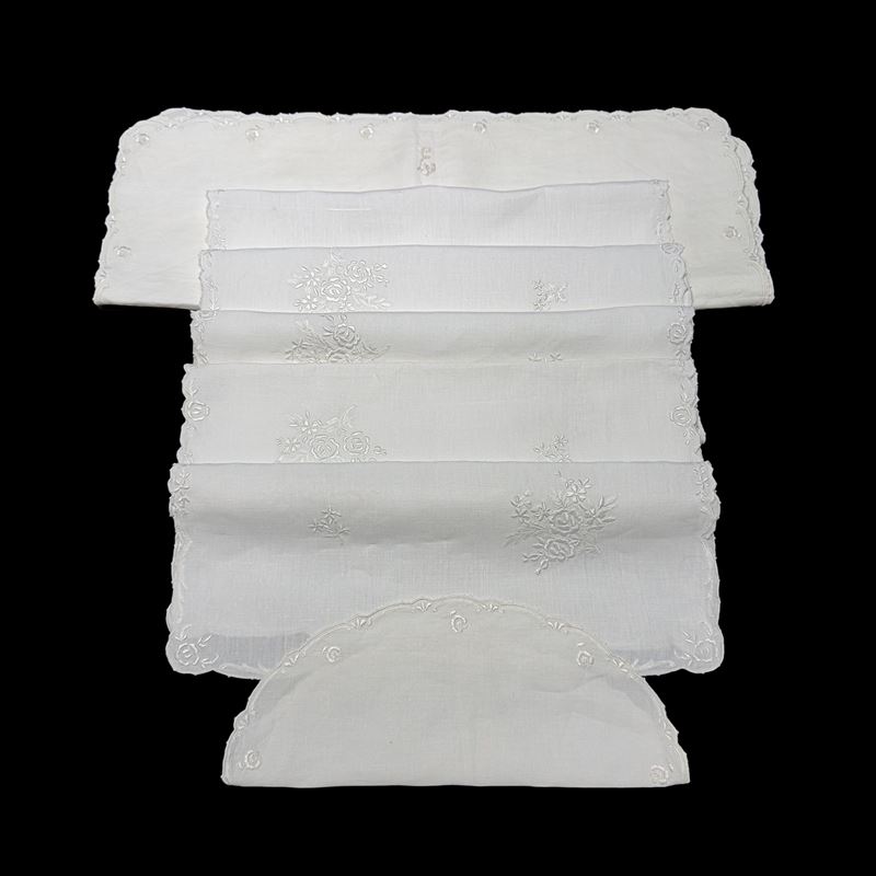 Tovaglia in lino bianco arricchita da ricami con mazzi di roselline