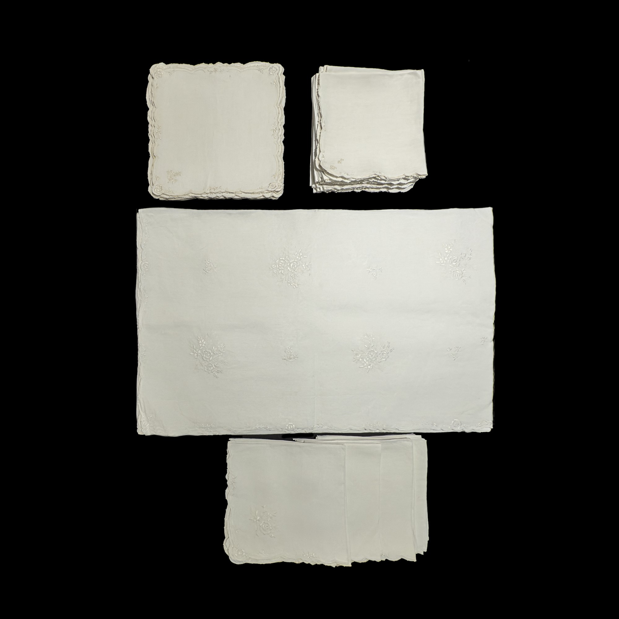 Tovaglia in lino bianco arricchita da ricami con mazzi di roselline