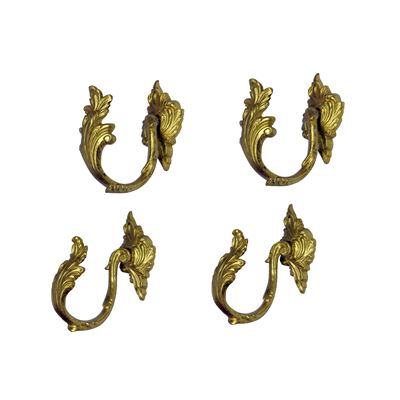 Porte embrasse in bronzo dorato, cesellate a voluta fogliata