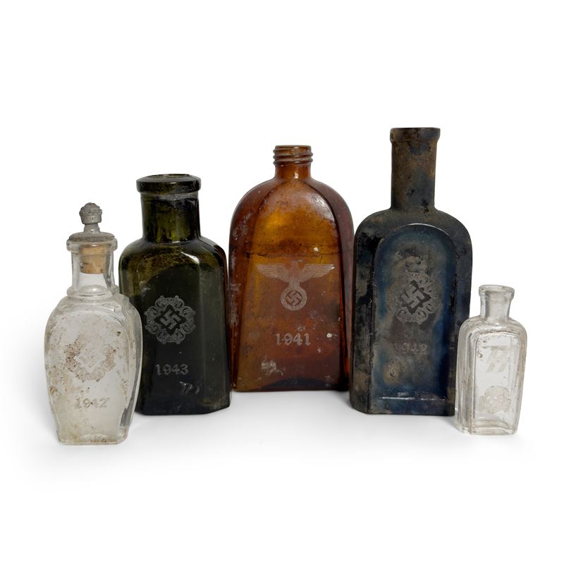 Cinque bottiglie in vetro, varie forme e colori, incisioni con croce uncinata, 1941-1944