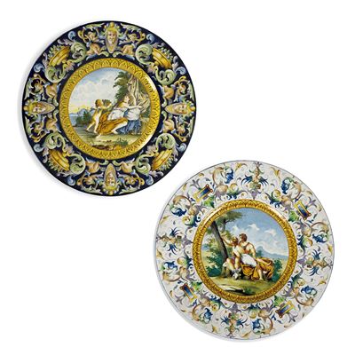 Due piatti in maiolica policroma, decorazioni a raffaellesche