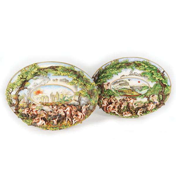 Coppia di piatti da muro in porcellana bianca, policroma e dorata