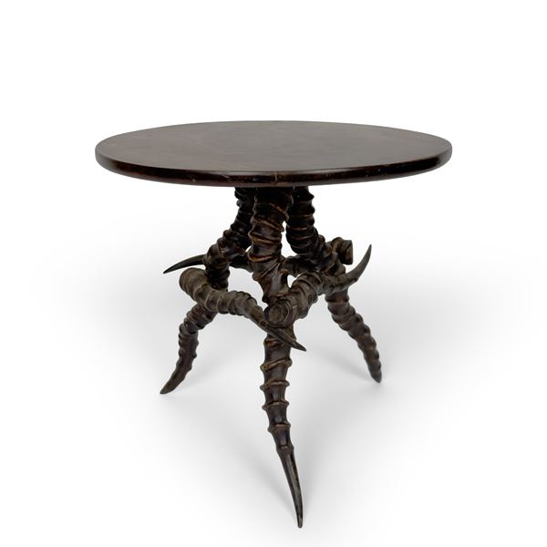 Sgabello con seduta circolare in legno sostenuto da corna di animale