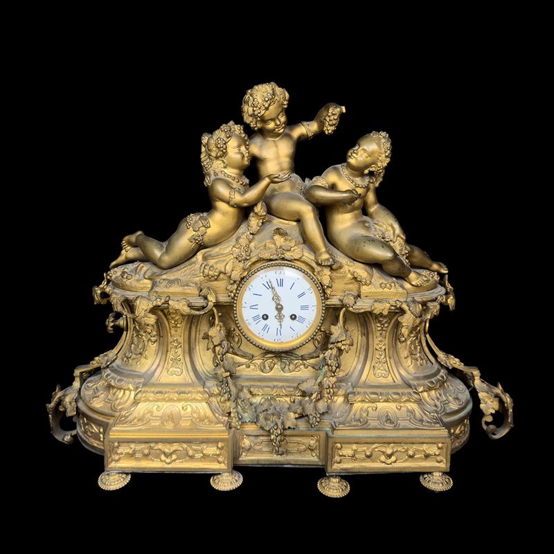 Pendola in bronzo dorato, Francia, XIX secolo, con figure di putti bacchici