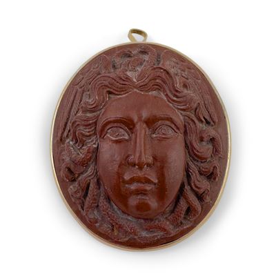 Placchetta ovale in marmo rosso antico, testa di Medusa in altorilievo, montata a spilla/pendente...