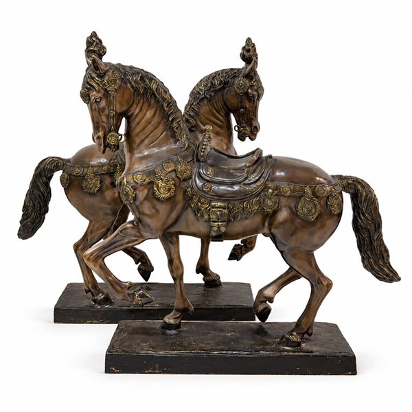 Coppia di cavalli bardati in bronzo patinato e dorato