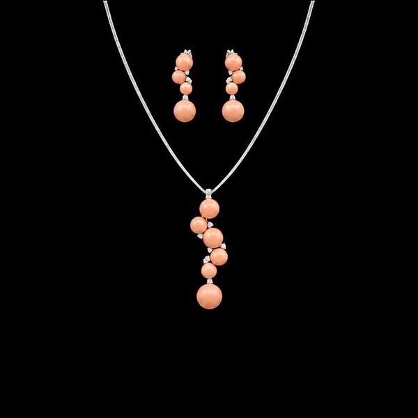 Collana e paio di orecchini in oro bianco 18kt., coralli pelle d’angelo cabochon e diamanti
